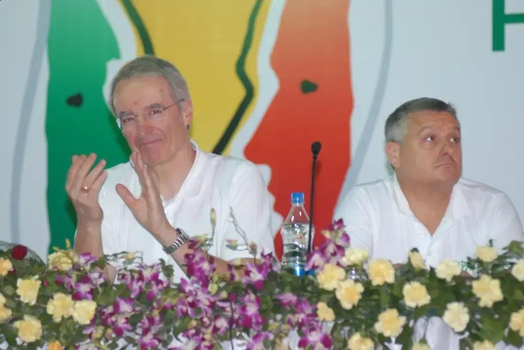 Man and woman speaking on stage at night with blue lighting